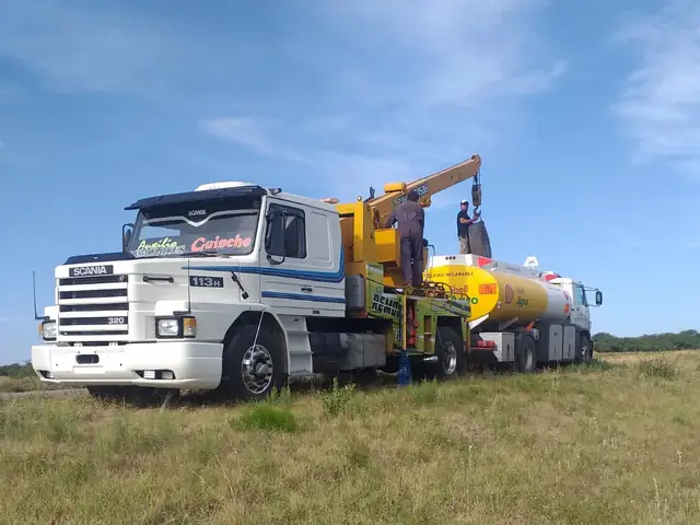 Guinche pesado junto a camión de carga en zona rural
