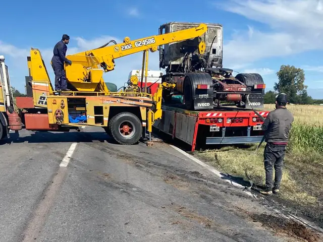 Grúa pesada asistiendo un camión rojo